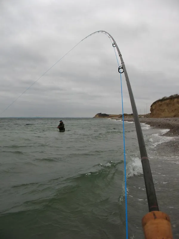 A bend - Fishing friend Henning visible under the arc of my bent fly rod - bent by a fish of course...